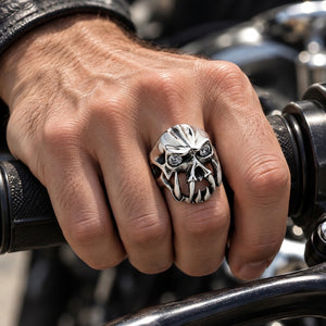 Sterling silver fang devil clear CZ ring worn on a natural hand gripping a motorcycle handlebar