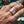 Close-up of a man's hand wearing a sterling silver Four Aces ring featuring engraved playing cards, set against a green poker