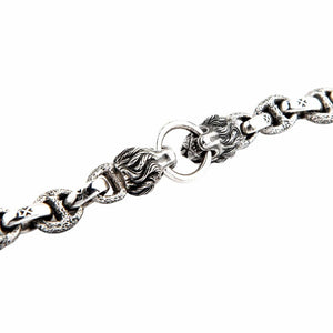 Close-up of sterling silver lion heads holding ring centerpiece with intricate mane detailing