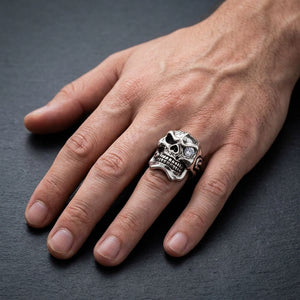 Sterling silver mafia skull ring with garnet and clear CZ worn naturally on a man's ring finger
