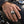 Sterling silver pirate skull CZ ring worn on a natural hand resting on a motorcycle tank
