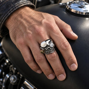 Sterling silver pirate skull CZ ring worn on a natural hand resting on a motorcycle tank