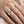 Woman wearing wide silver cherry blossom ring on finger