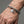 Sterling silver wolf and gothic cross link bracelet worn on wrist for scale