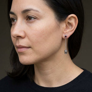 Sugar Skull Sterling Silver Dangle Earrings, worn correctly through one visible earlobe in three-quarter profile