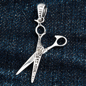 Engraved Scissors Sterling Silver Pendant shown in open scissors on denim view.