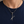 Engraved Scissors Sterling Silver Pendant with engraved open blades over a navy shirt.