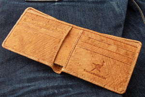 Tan Full-Quill Ostrich Leather Bifold Wallet showing the cowhide card rows inside the wallet on denim.