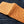 Tan Full-Quill Ostrich Leather Bifold Wallet showing the ostrich exterior opened across both panels.