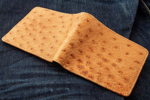 Tan Full-Quill Ostrich Leather Bifold Wallet showing the ostrich exterior opened across both panels.