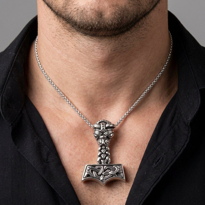 Norse knotwork Thor's hammer sterling silver pendant worn by an adult man in a black shirt
