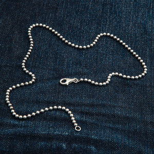 3 mm sterling zilveren bolletjesketting. De zilveren kralenketting is in een lus op denim gelegd.
