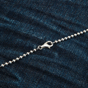 3 mm sterling zilveren bolletjesketting. De gesloten karabijnsluiting verbindt twee lengtes van de zilveren bolletjesketting op denim.