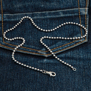 3 mm sterling zilveren bolletjesketting. De ketting ligt diagonaal op denim, met beide eindstukken zichtbaar.