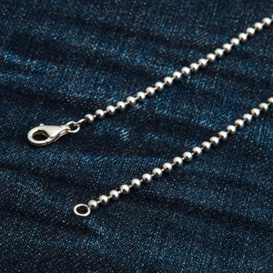 3 mm sterling zilveren bolletjesketting. De sluiting en de uiteinden van de bolletjesketting rusten op blauw denim.