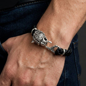 Large tiger head sterling silver and black braided leather bracelet worn on a man's wrist