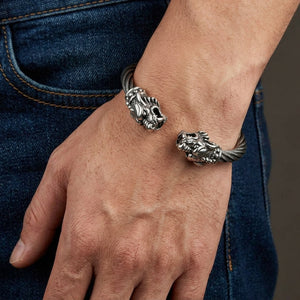 Brazalete rígido de cabeza de tigre en plata de ley y cable de acero, llevado de forma natural alrededor de la muñeca con el cierre visible