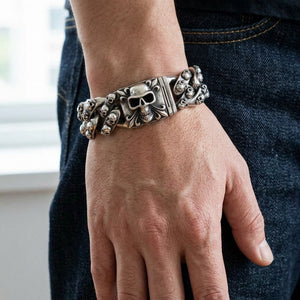 Pulseira tribal com múltiplas caveiras em prata de lei 925 usada no pulso de um adulto