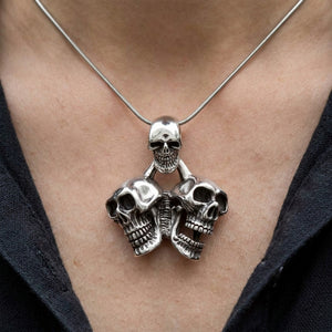 Triple Skull Sterling Silver Pendant, worn on the neck with collarbones, shoulders and upper chest visible