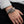 Bracciale cuff in argento a doppio drago con occhi di rubino indossato su un polso accanto a una manica grigia arrotolata.