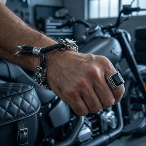Pulseira de couro e prata de lei 925 Twin Dragon no pulso do modelo original num ambiente escuro de oficina de motas