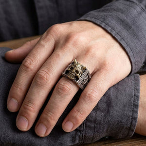 Anillo de plata con calavera vikinga y martillo puesto en una mano, mostrando el frontal del anillo y el aro