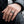 Anillo de plata con corazón alado de la paz en una mano, mostrando la parte frontal y la banda del anillo