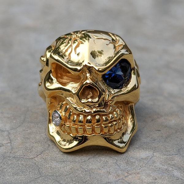Кольцо с черепом и голубым глазом из желтого золота с микронами